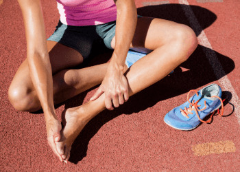 Female athlete with foot pain on running track