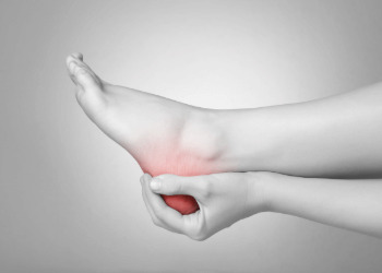a foot in a hand having heel pain
